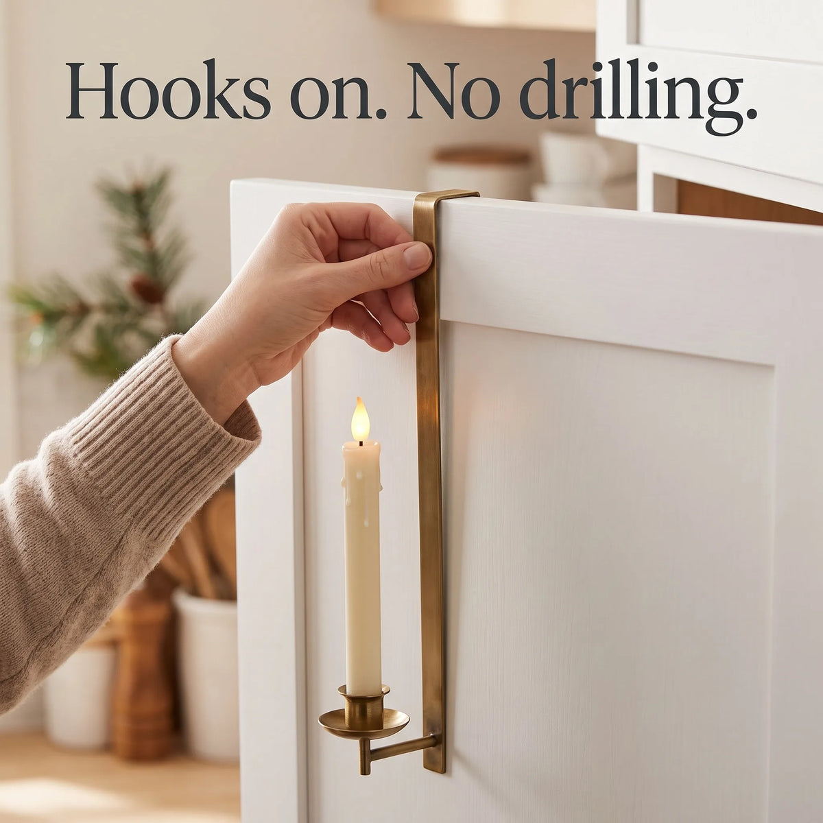 Hand hooking a brass candle holder over the top of a cabinet door