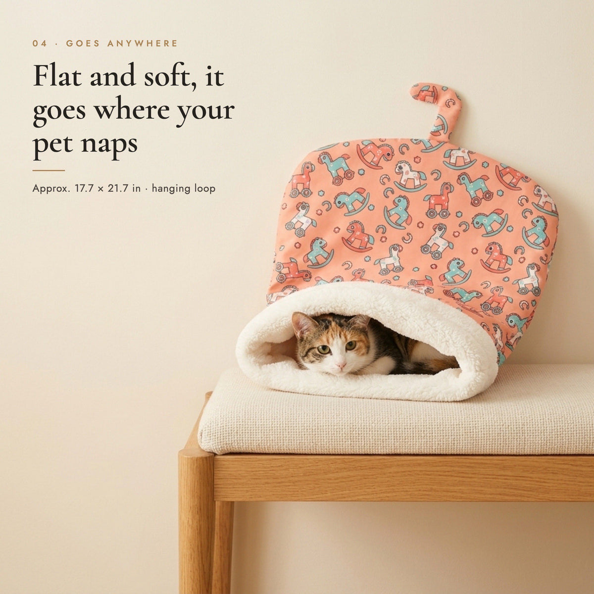 Calico cat resting in a Coral Pony pet sleeping bag on a wooden bench, hanging loop at the top